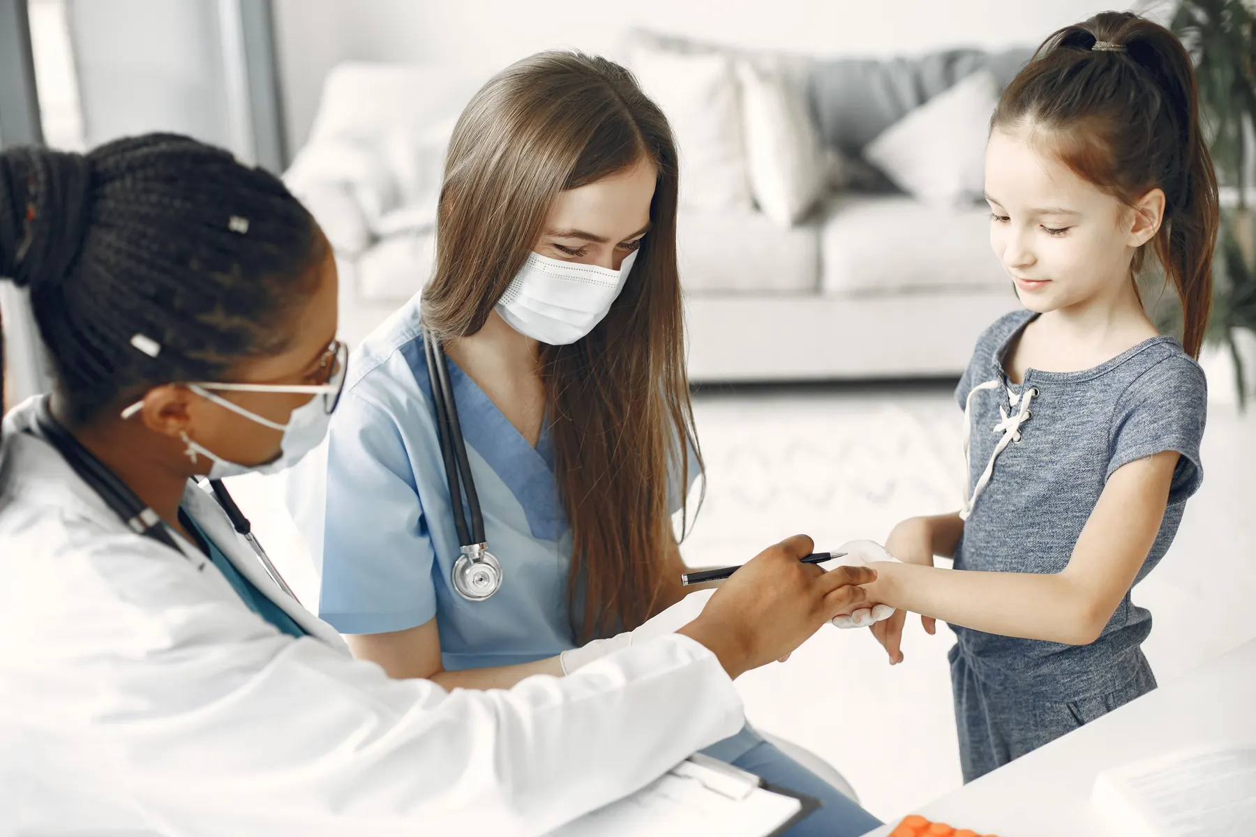 Healthcare professionals helping a child during a checkup.