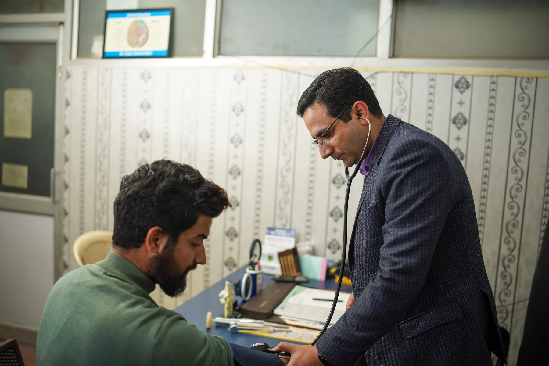 A primary care professional examining a patient.